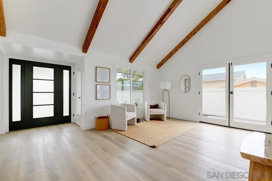 Entry with black front door and exposed beams