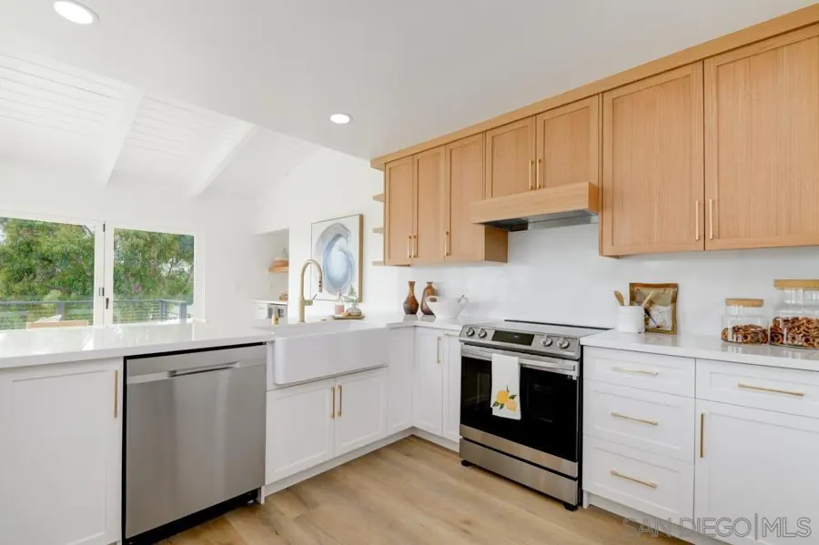 Kitchen with white and oak cabinets and farmhouse sink