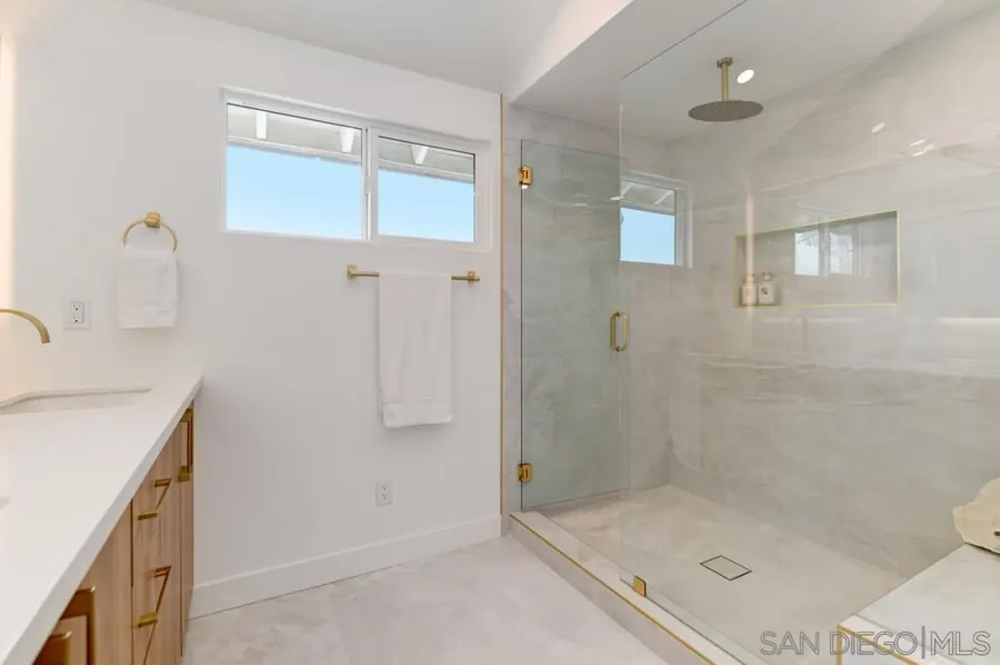 Bathroom with glass walk-in shower and brass fixtures
