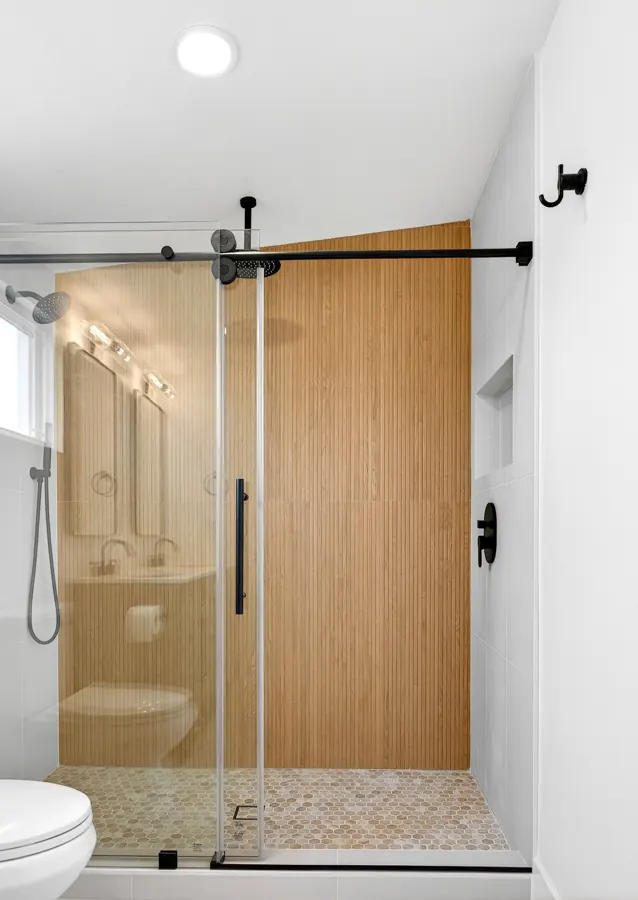 Walk-in shower with wood-look fluted tile and sliding glass door