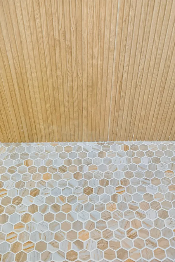Fluted wood-look tile meeting hexagon shower floor