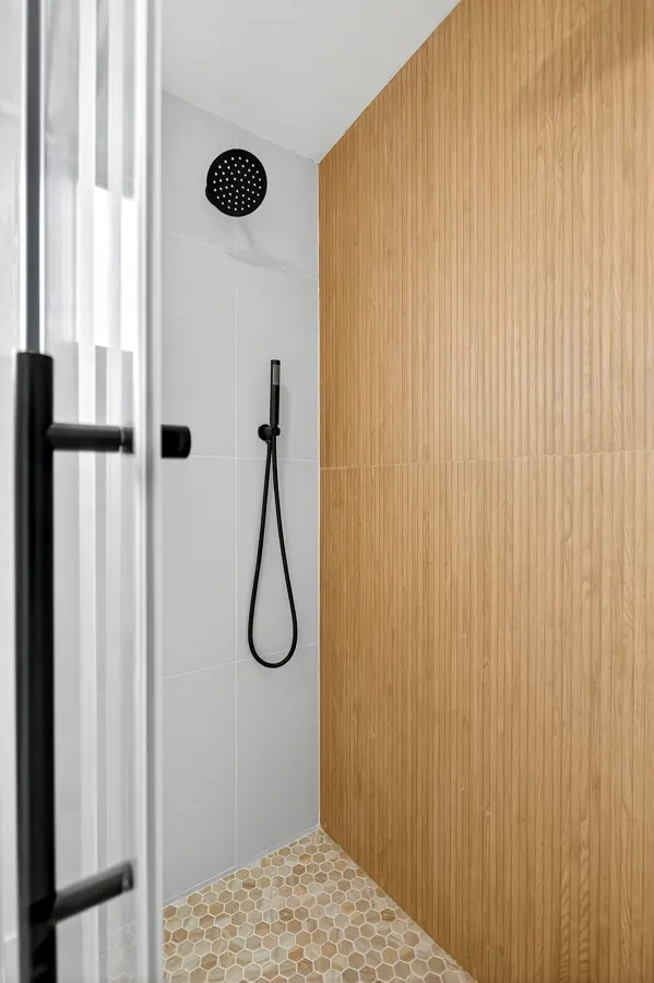 Shower with hand shower and fluted wood-look wall