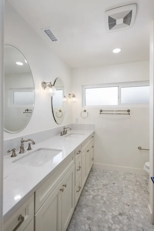 Bathroom with double vanity and oval mirrors