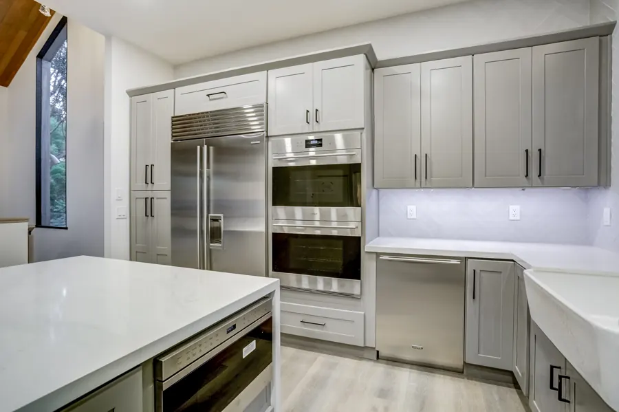 Kitchen appliance wall with built-in refrigerator and double ovens