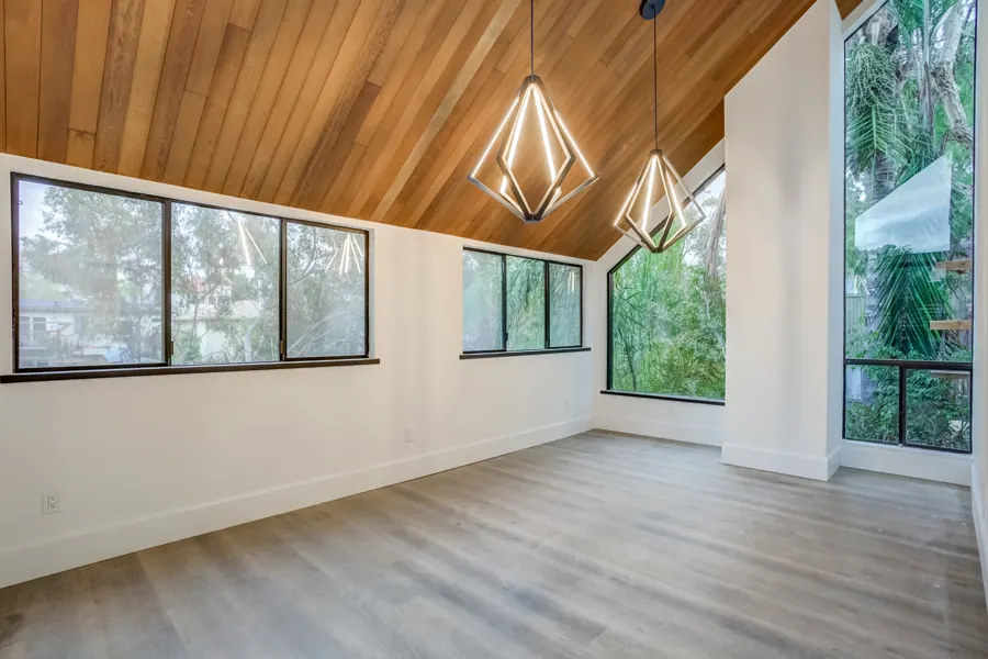 Dining room with vaulted wood ceiling and geometric pendants