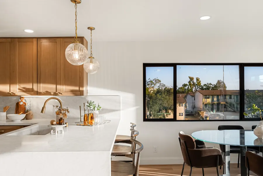 Mission Hills 2: Kitchen peninsula with oak cabinets, globe pendants and dining area by the window