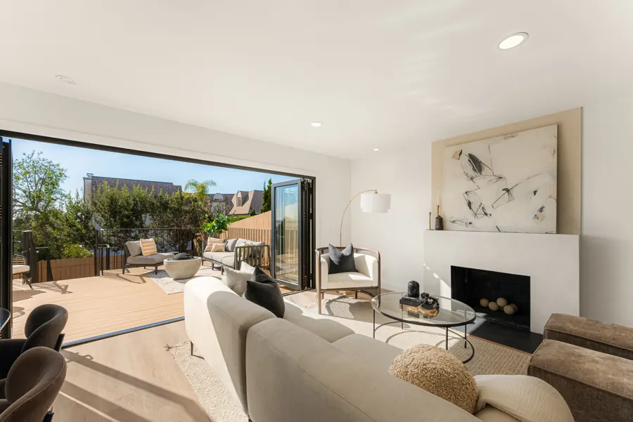 Living room with plaster fireplace and folding doors to the deck