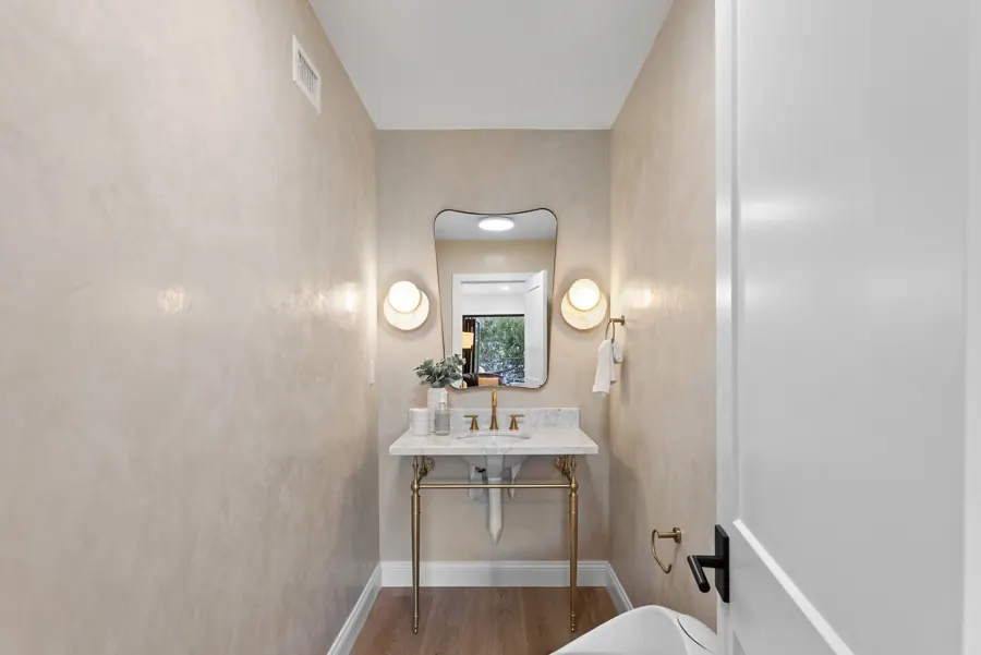 Powder room with plaster walls and brass console sink