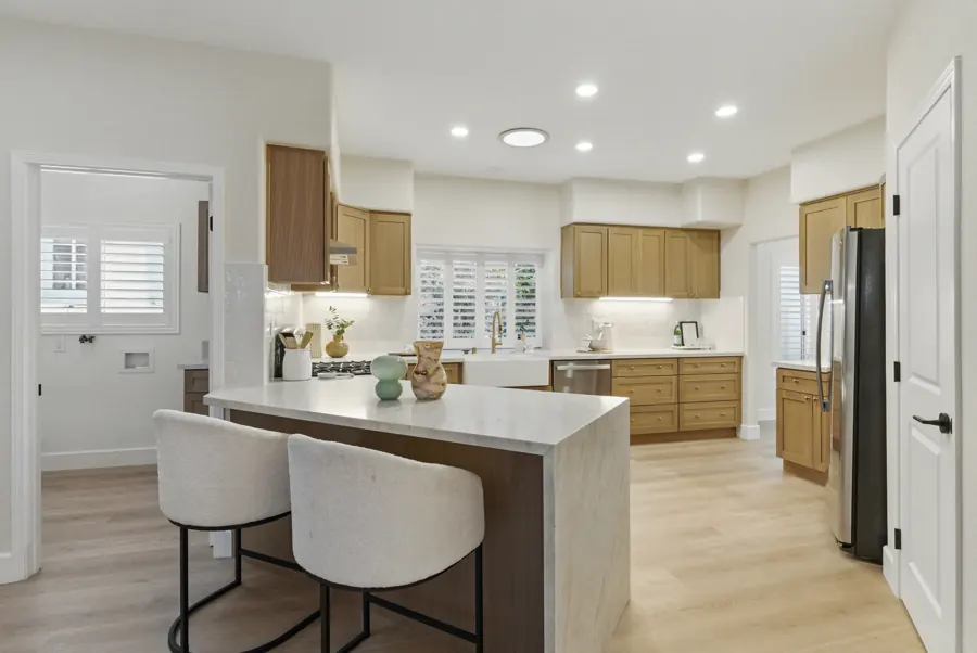 Kitchen with oak cabinets and waterfall peninsula