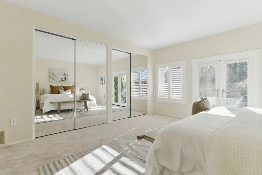 Bedroom with mirrored closet doors and French doors
