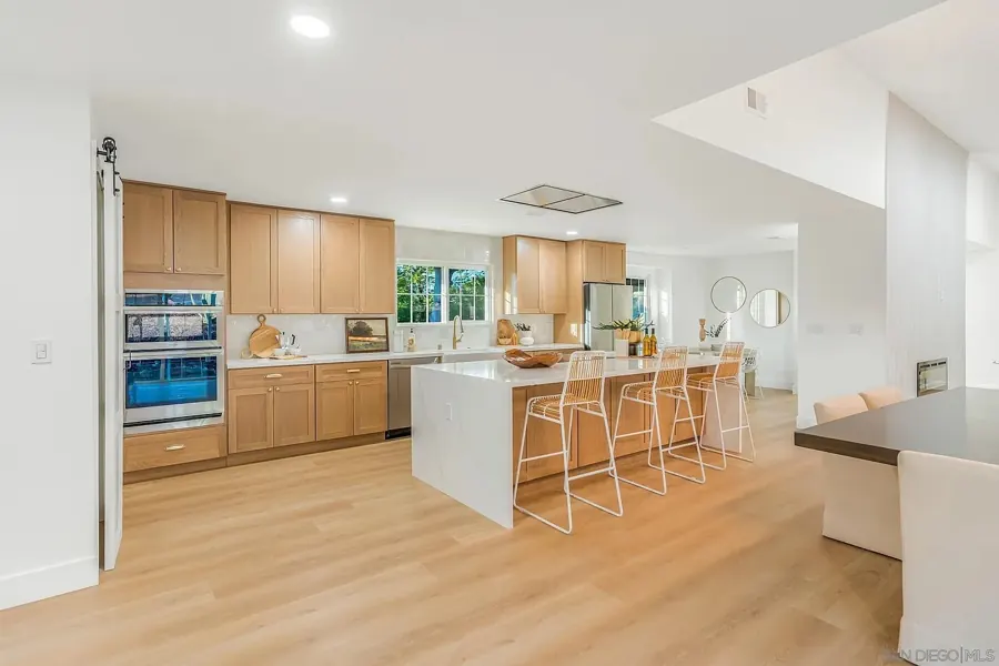Kitchen with oak cabinets, double ovens and island seating