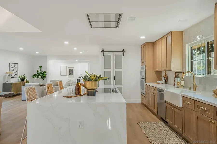 Waterfall island with cooktop and family room beyond