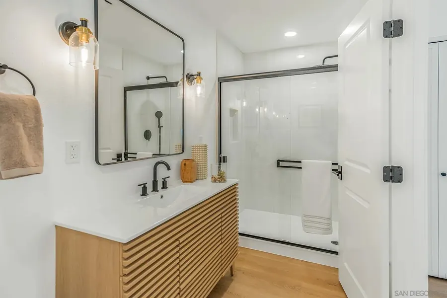 Bathroom with slatted oak vanity and glass shower