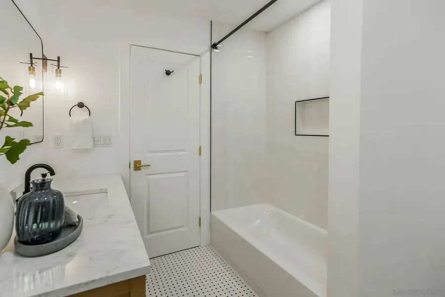 Bathroom with tub and mosaic tile floor