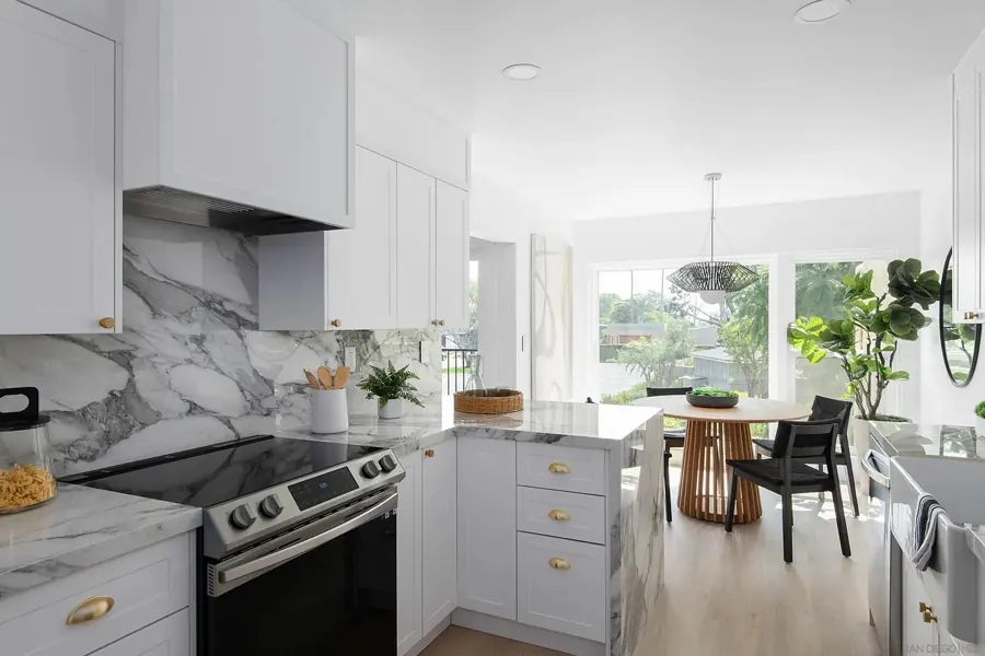 White kitchen with marble backsplash looking toward the dining nook
