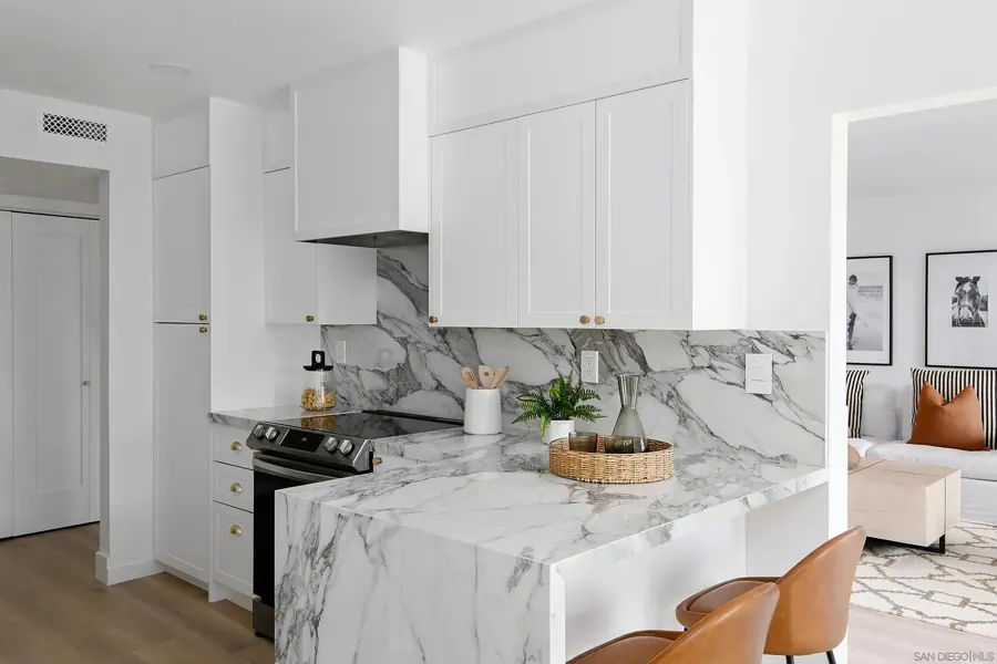Kitchen peninsula with marble waterfall edge and leather stools